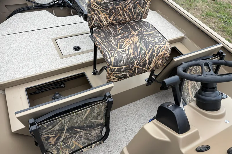 Slide: The Image of 2026 SeaArk Shadow 20V boat interior with camo seats and storage compartments. - 13