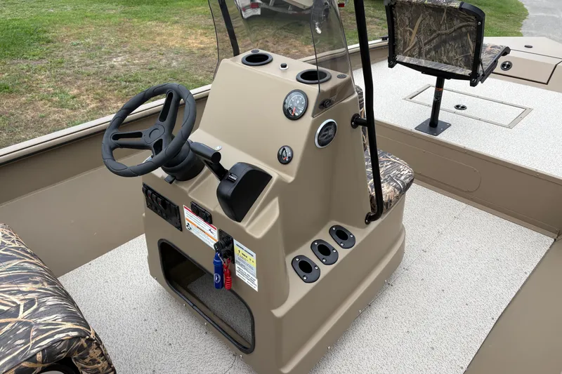 Slide: The Image of 2026 SeaArk Shadow 20V boat interior with steering console and camo seating. - 15