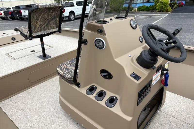 Slide: The Image of 2026 SeaArk Shadow 20V boat interior with steering console and camo seating. - 16