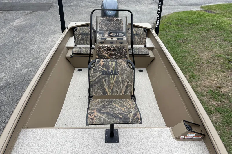 Slide: The Image of 2026 SeaArk Shadow 20V boat interior with camouflage seating and steering console. - 18
