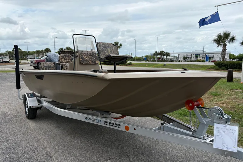 Slide: The Image of 2026 SeaArk Shadow 20V boat on trailer, parked outdoors with palm trees in background. - 5
