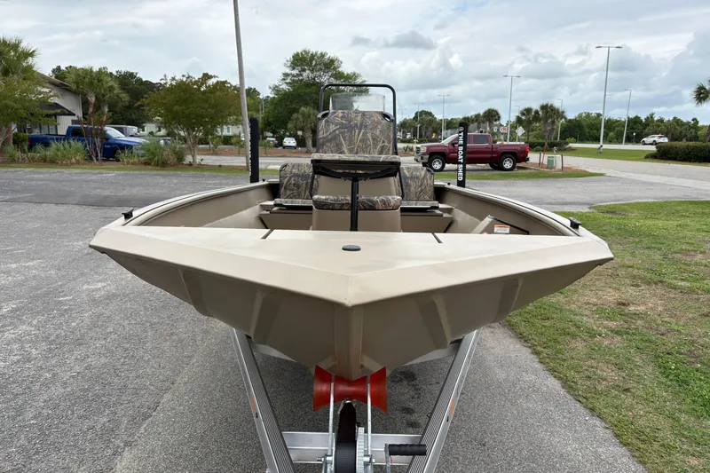 Slide: The Image of 2026 SeaArk Shadow 20V boat on trailer, camo seats, parked outdoors. - 6