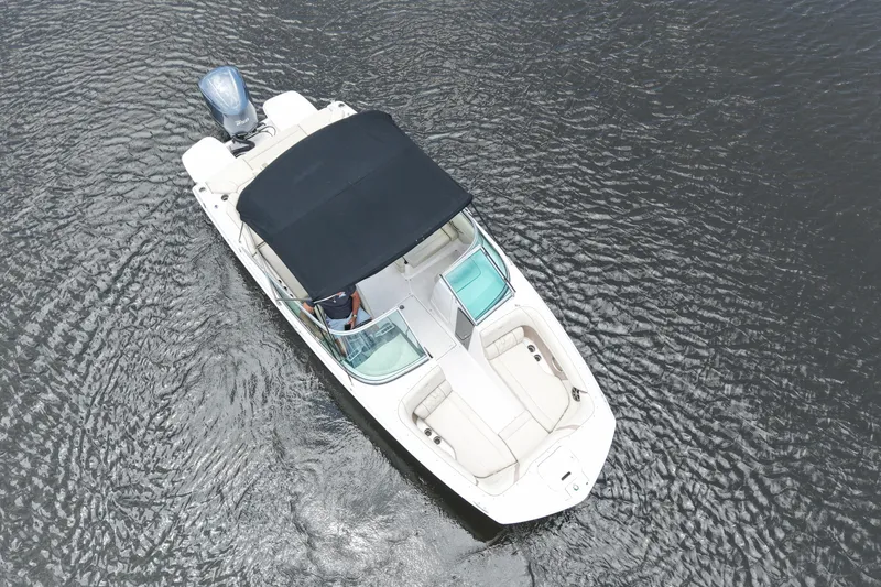 Slide: The Image of Aerial view of 2019 Regal 23 OBX boat on water with black canopy. - 10