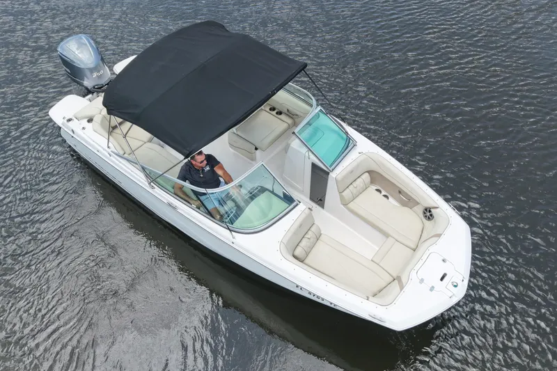 Slide: The Image of 2019 Regal 23 OBX boat with black canopy cruising on water. - 11