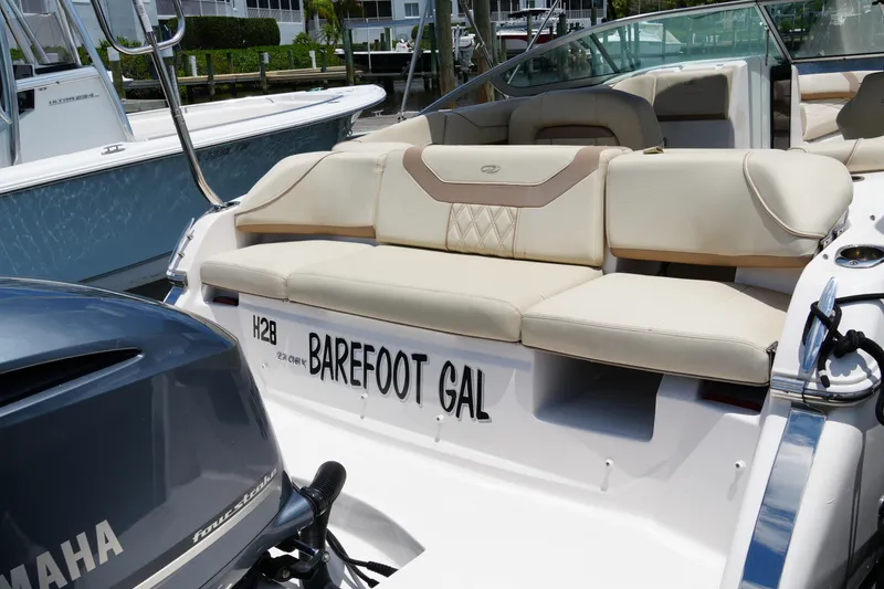 Slide: The Image of 2019 Regal 23 OBX boat with Yamaha engine, named "Barefoot Gal," docked at marina. - 12