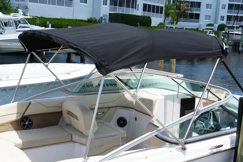 Slide: The Image of 2019 Regal 23 OBX boat with black canopy docked at marina. - 16