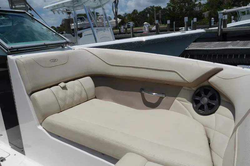 Slide: The Image of Luxurious seating on a 2019 Regal 23 OBX boat, featuring beige upholstery and speaker. - 22