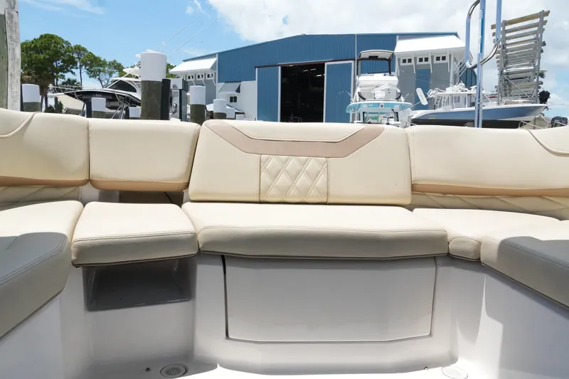 Slide: The Image of 2019 Regal 23 OBX boat interior with beige seating, docked near a marina. - 29