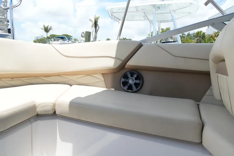 Slide: The Image of Luxurious seating on a 2019 Regal 23 OBX boat, featuring beige upholstery and built-in speaker. - 30