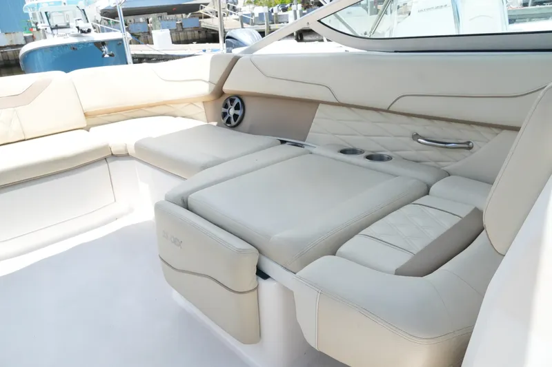 Slide: The Image of Luxurious seating on a 2019 Regal 23 OBX boat, featuring beige upholstery and cup holders. - 32