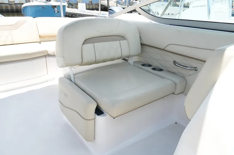 Slide: The Image of Luxurious seating on a 2019 Regal 23 OBX boat, featuring cream upholstery and cup holders. - 33