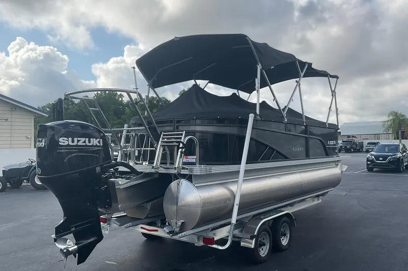 Slide: The Image of 2023 Crest Classic DLX 220 SLC pontoon boat with Suzuki outboard motor on trailer. - 12