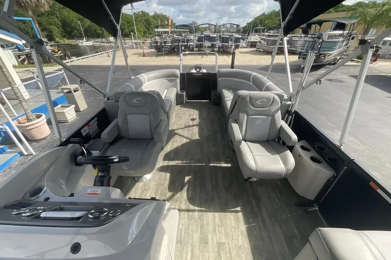 Slide: The Image of 2023 Crest Classic DLX 220 SLC pontoon boat interior with plush seating and modern controls. - 17