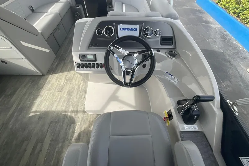 Slide: The Image of 2023 Crest Classic DLX 220 SLC boat helm with steering wheel and control panel. - 18
