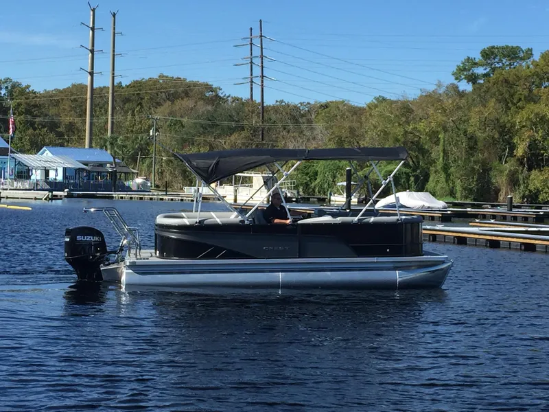 Slide: The Image of 2023 Crest Classic DLX 220 SLC pontoon boat on calm water. - 2