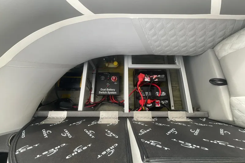 Slide: The Image of 2023 Crest Classic DLX 220 SLC boat battery compartment with dual battery switch system. - 20