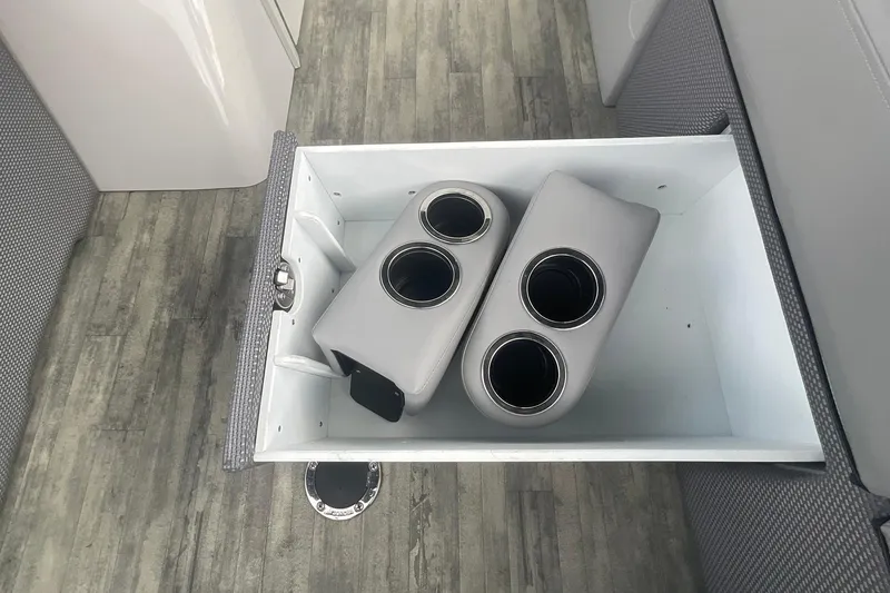 Slide: The Image of Storage compartment with cup holders in 2023 Crest Classic DLX 220 SLC boat interior. - 21