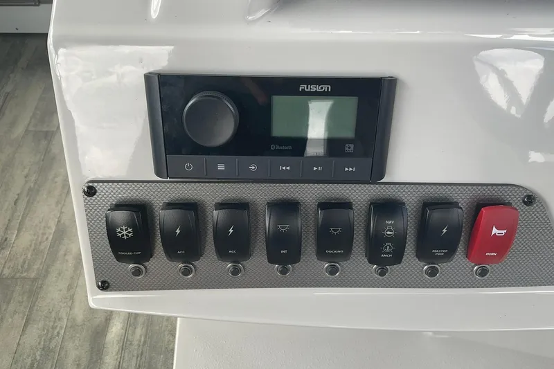 Slide: The Image of Control panel of 2023 Crest Classic DLX 220 SLC with switches and Fusion audio system. - 24