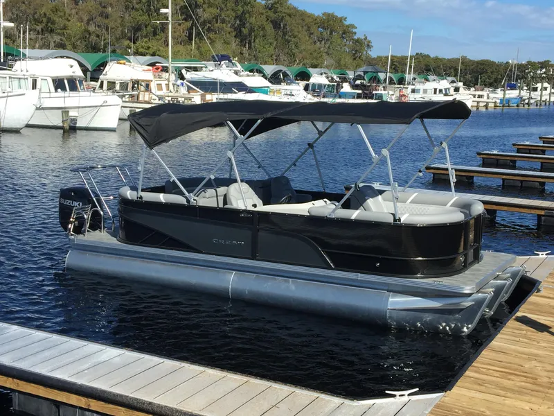 Slide: The Image of 2023 Crest Classic DLX 220 SLC pontoon boat docked at marina. - 3