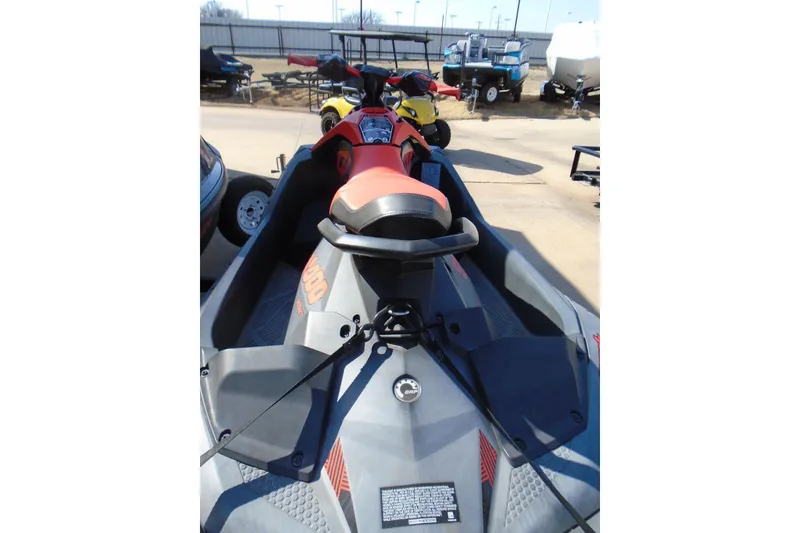 Slide: The Image of 2022 Sea-Doo Spark Trixx 3up jet ski, vibrant red and black design, parked outdoors. - 3