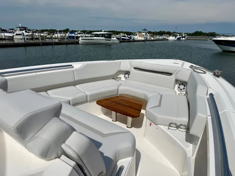 Slide: The Image of The 2027 Tiara Yachts 43LS features a luxurious seating area with a wooden table, overlooking a marina. - 18