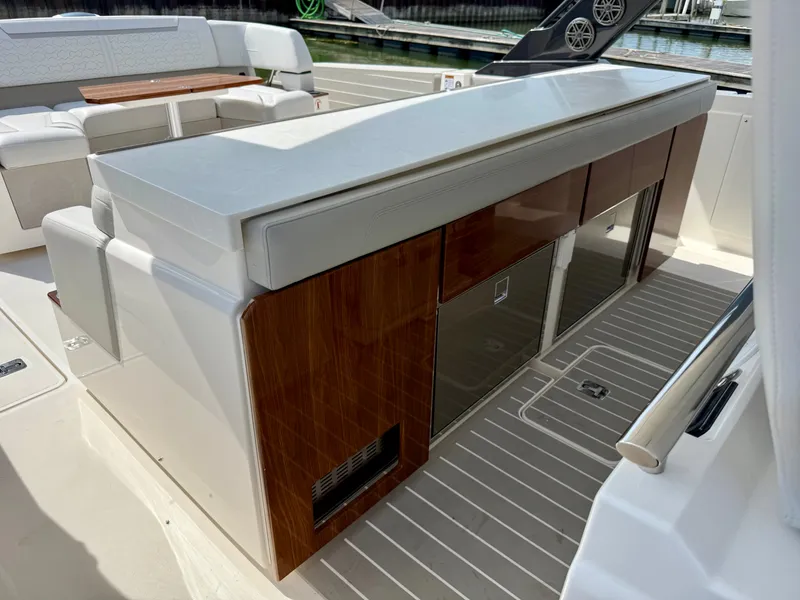 Slide: The Image of The 2027 Tiara Yachts 43LS features a sleek outdoor kitchen with wood paneling and modern appliances. - 23