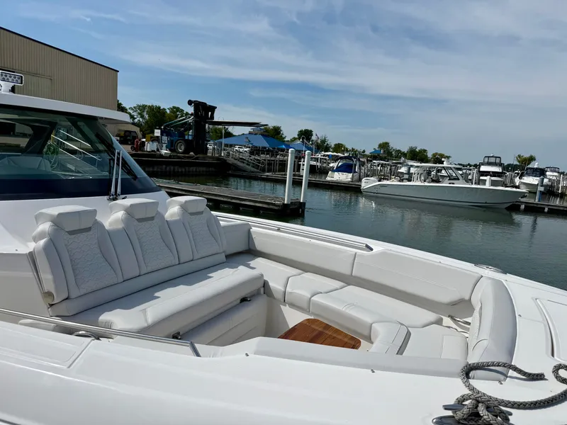 Slide: The Image of The image shows the deck of a 2027 Tiara Yachts 43LS with white seating at a marina. - 4