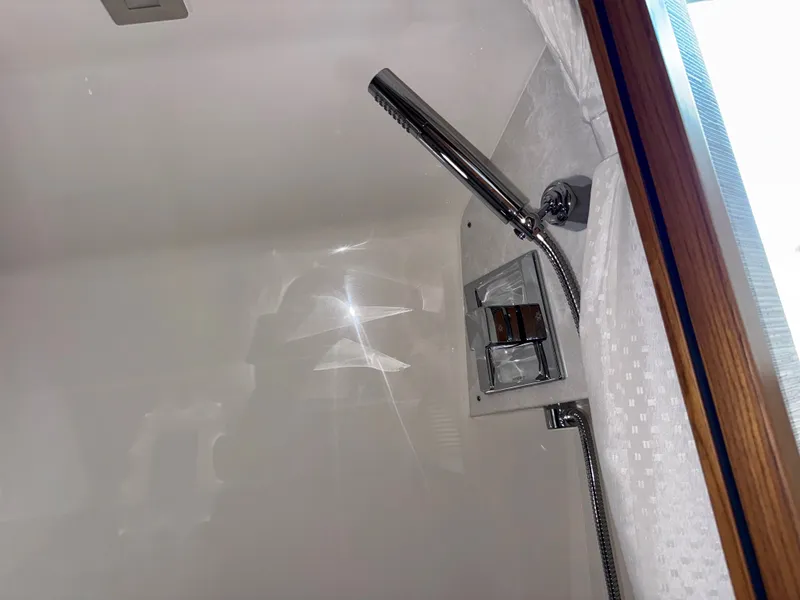 Slide: The Image of A modern shower fixture in a sleek, white bathroom with wood trim. - 29