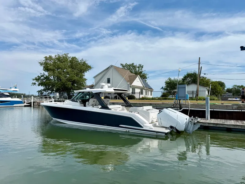 Slide: The Image of 2027 Tiara Yachts 43LS in the water, featuring a sleek design and three outboard engines. - 1