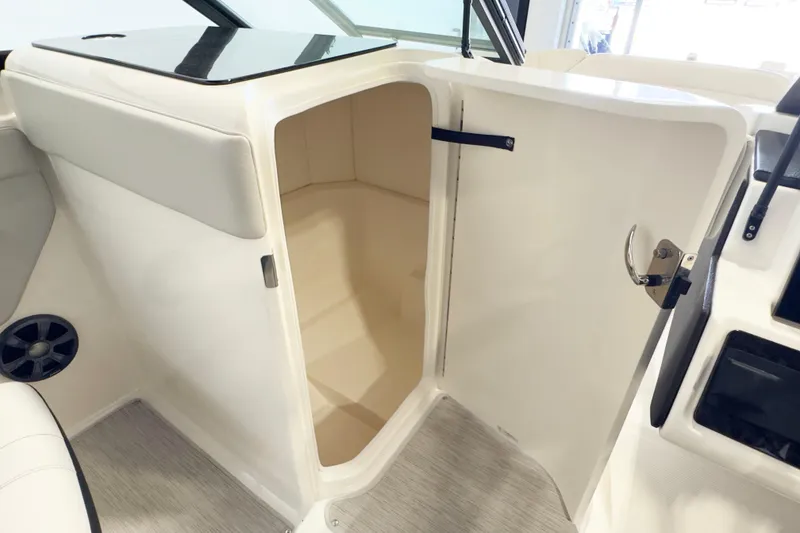 Slide: The Image of 2021 Sea Ray SPX 230 boat interior storage compartment with open door. - 12