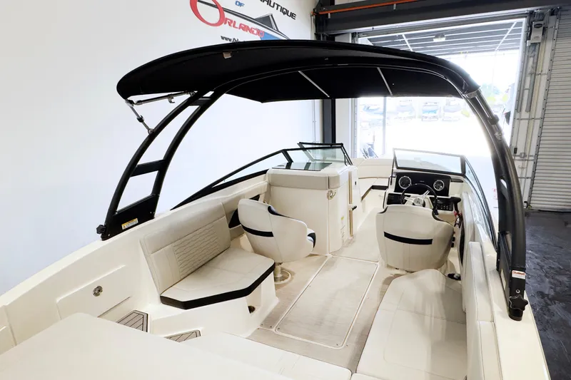 Slide: The Image of 2021 Sea Ray SPX 230 boat interior with seating and steering wheel in a showroom. - 4