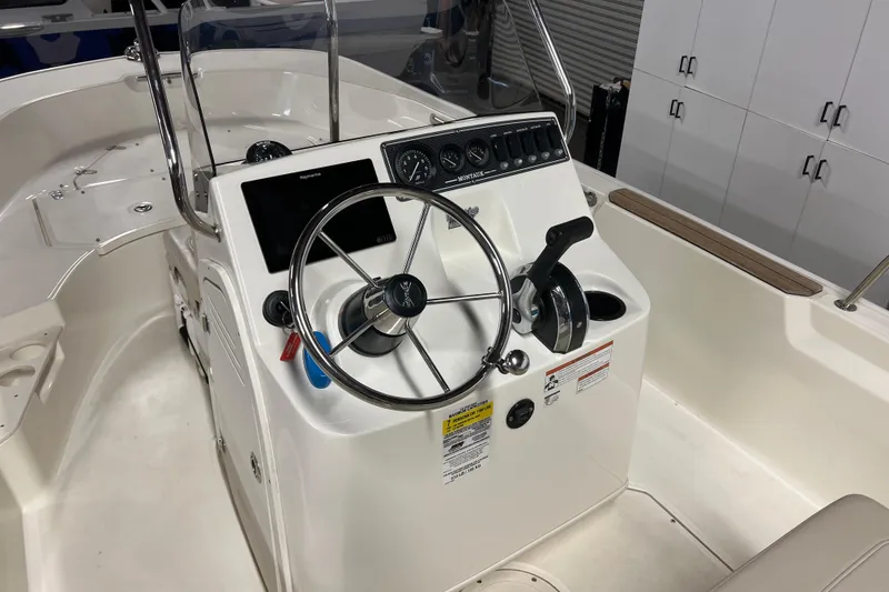 Slide: The Image of 2019 Boston Whaler 170 Montauk boat console with steering wheel and controls. - 10