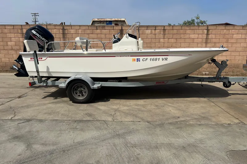 Slide: The Image of 2019 Boston Whaler 170 Montauk boat on trailer, parked outdoors. - 15