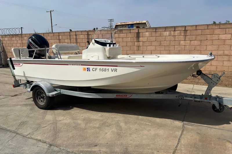 Slide: The Image of 2019 Boston Whaler 170 Montauk boat on trailer, parked outdoors. - 16