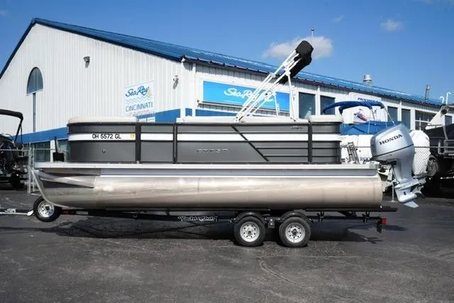 The Image of 2021 Crest Classic DLX 200 L pontoon boat on trailer outside dealership. - 1