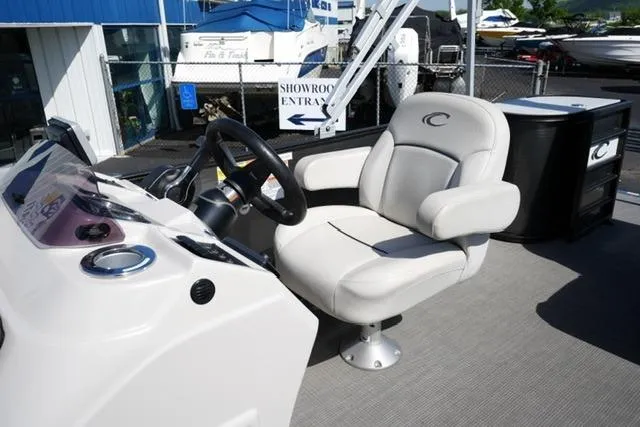 Slide: The Image of 2021 Crest Classic DLX 200 L boat interior with captain's chair and steering console. - 12