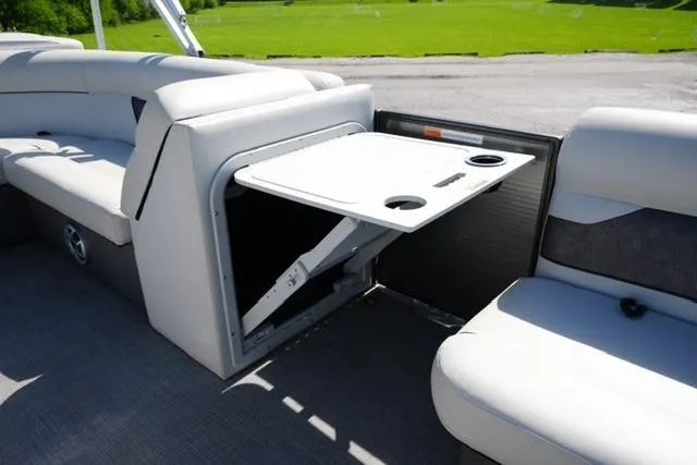 Slide: The Image of 2021 Crest Classic DLX 200 L pontoon boat interior with fold-out table and cup holders. - 16