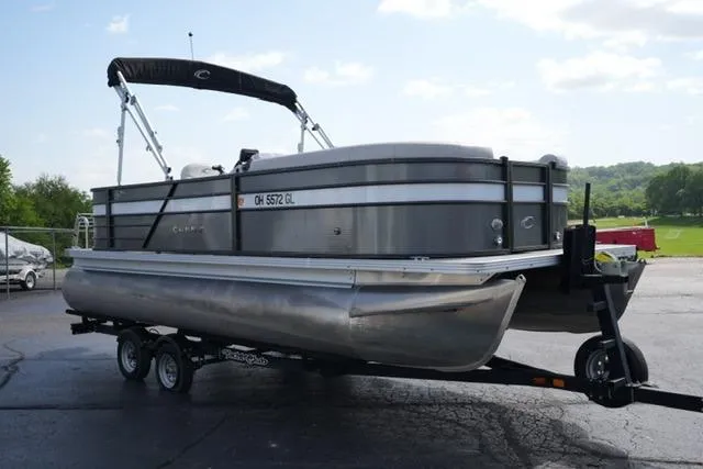Slide: The Image of 2021 Crest Classic DLX 200 L pontoon boat on trailer, parked outdoors. - 3