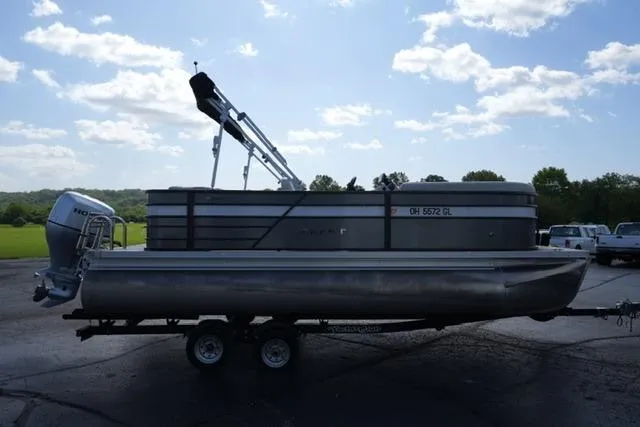 Slide: The Image of 2021 Crest Classic DLX 200 L pontoon boat on trailer under a partly cloudy sky. - 4