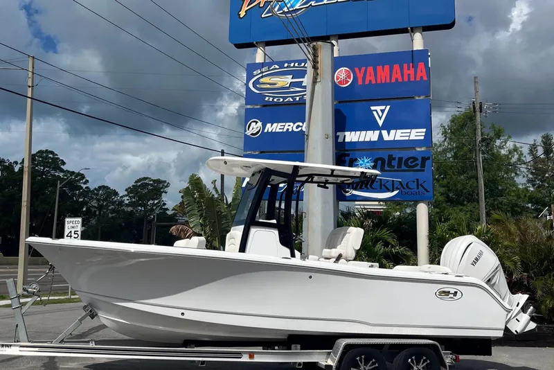 Slide: The Image of 2026 Sea Hunt Ultra 235 SE boat on trailer, displayed at dealership with brand signage. - 1