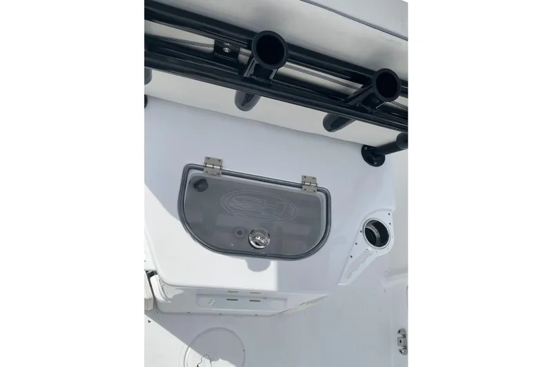 Slide: The Image of 2026 Sea Hunt Ultra 235 SE boat interior with storage compartment and rod holders. - 16
