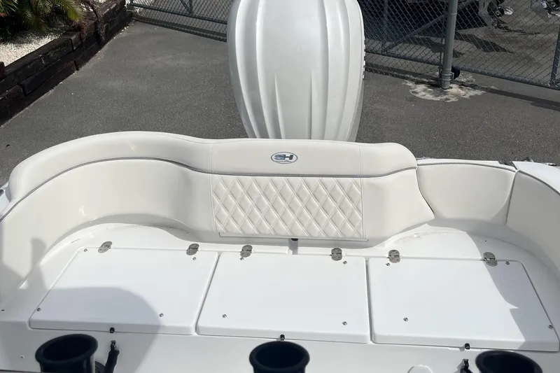 Slide: The Image of 2026 Sea Hunt Ultra 235 SE boat interior with white cushioned seating and storage compartments. - 18