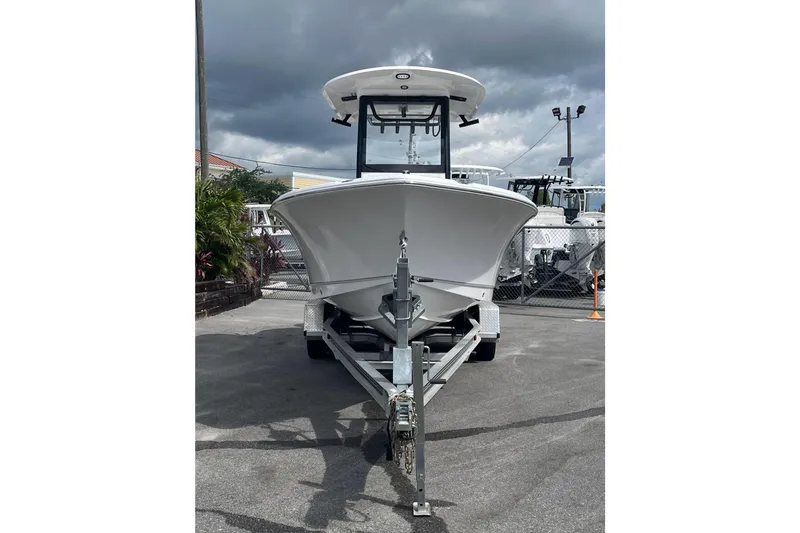 Slide: The Image of 2026 Sea Hunt Ultra 235 SE boat on trailer, parked outdoors under cloudy sky. - 2