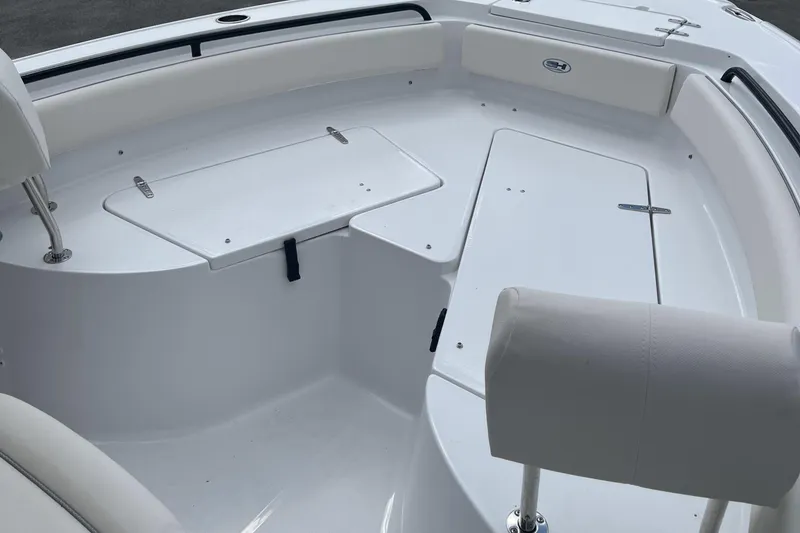 Slide: The Image of 2026 Sea Hunt Ultra 235 SE boat interior with white seating and storage compartments. - 22