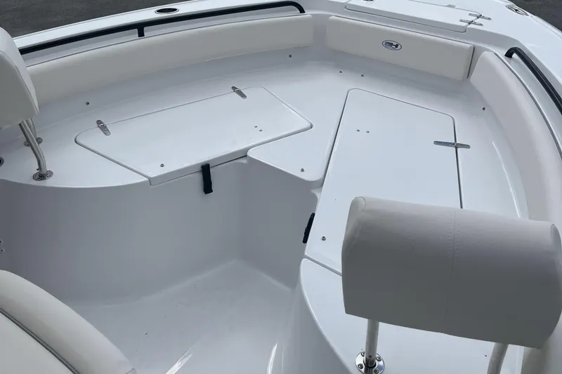 Slide: The Image of 2026 Sea Hunt Ultra 235 SE boat interior with white seating and storage compartments. - 23