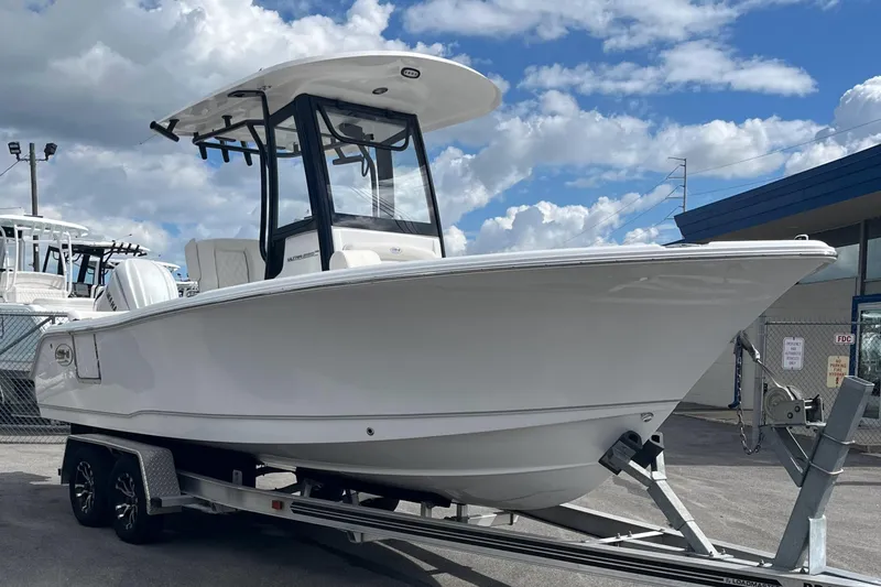 Slide: The Image of 2026 Sea Hunt Ultra 235 SE boat on trailer under cloudy sky. - 4