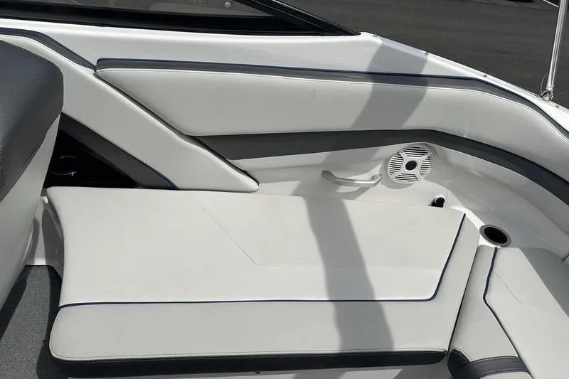 Slide: The Image of 2020 Yamaha Boats SX240 interior seating with white upholstery and integrated speaker. - 19
