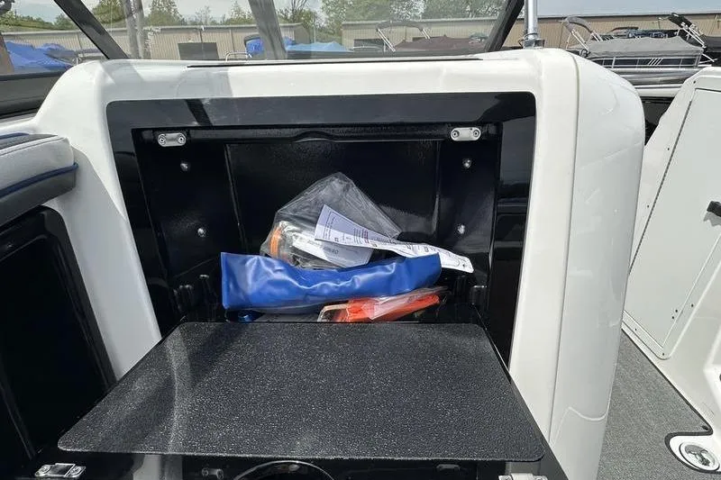 Slide: The Image of 2020 Yamaha Boats SX240 storage compartment with boating accessories inside. - 28