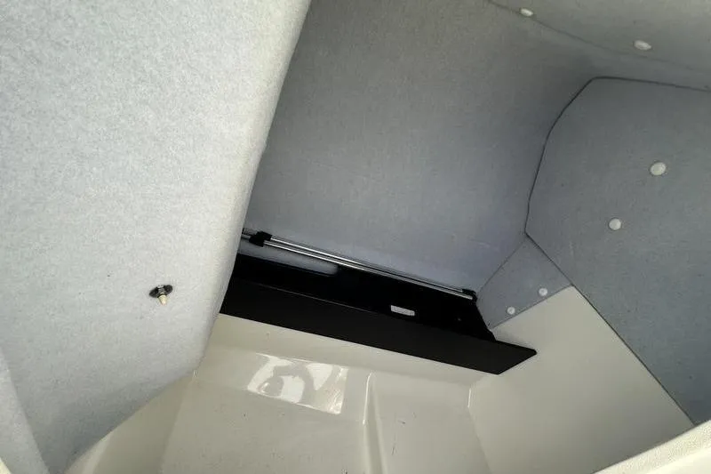 Slide: The Image of Interior storage compartment of 2020 Yamaha Boats SX240, featuring carpeted walls and secure latch. - 33