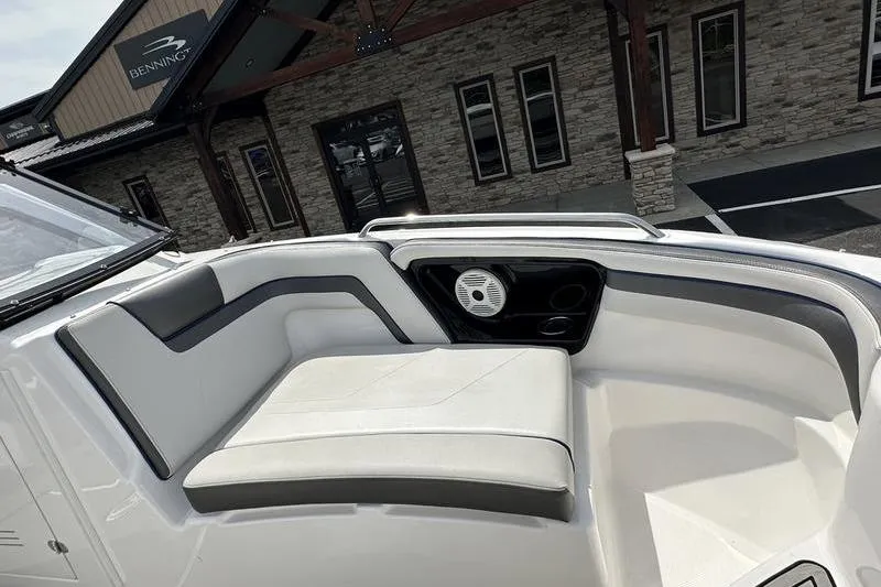 Slide: The Image of 2020 Yamaha Boats SX240 interior seating with speaker, near a stone building. - 38